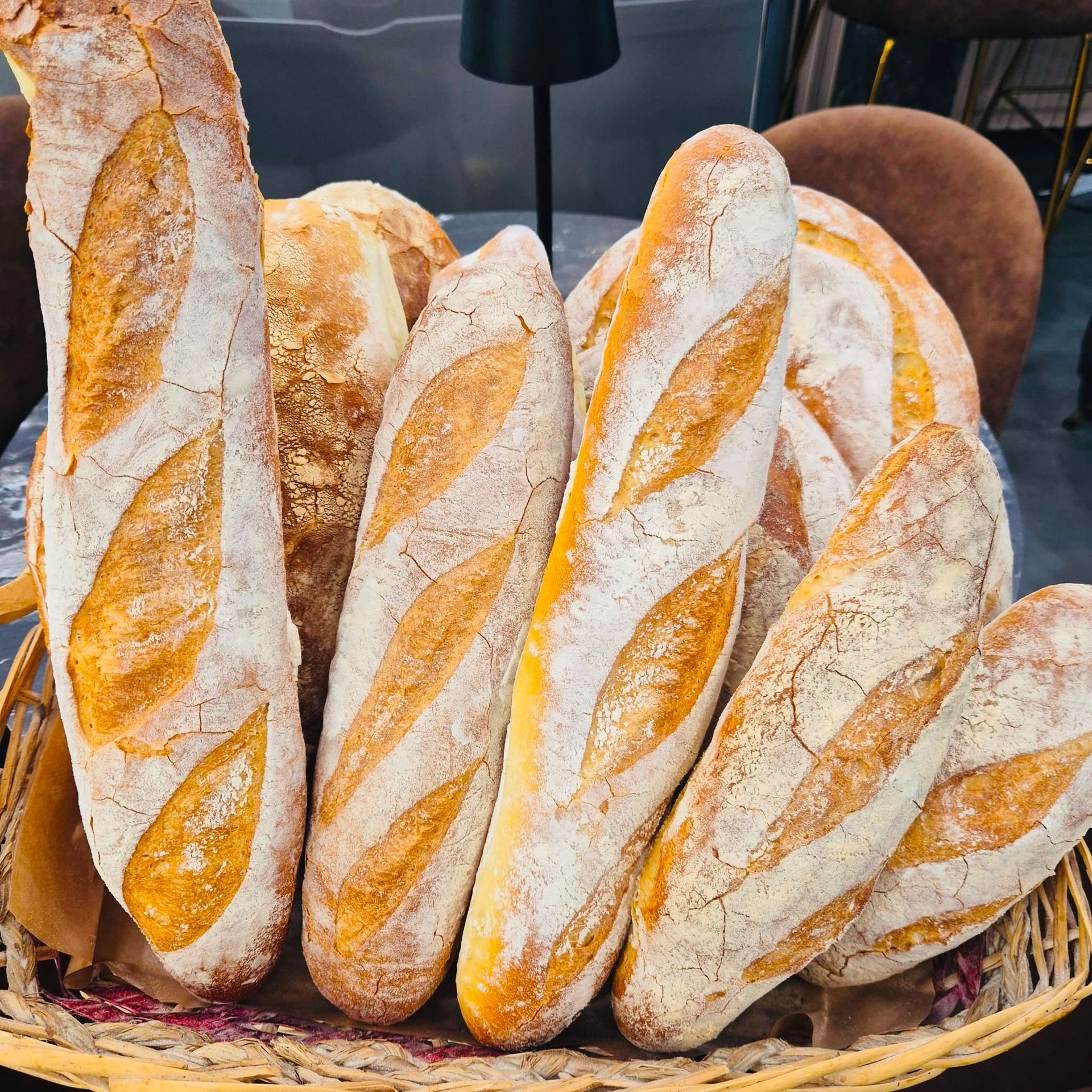 Cesto di baguette rustiche con crosta dorata e tagli diagonali
