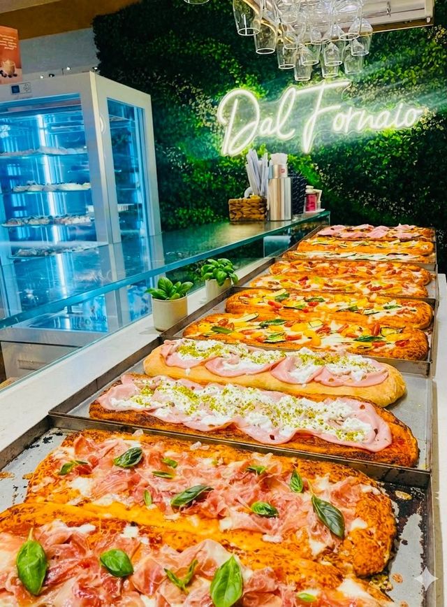 Diverse pizze sono esposte su un bancone del buffet