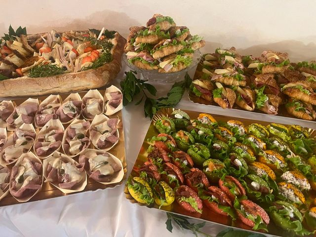 Su un tavolo di un buffet sono disposti vari vassoi di stuzzichini e snack colorati.