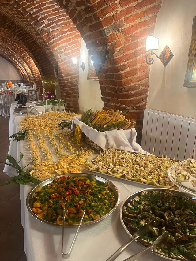 Tavolo a buffet con insalate e piatti assortiti in una sala da pranzo con soffitto