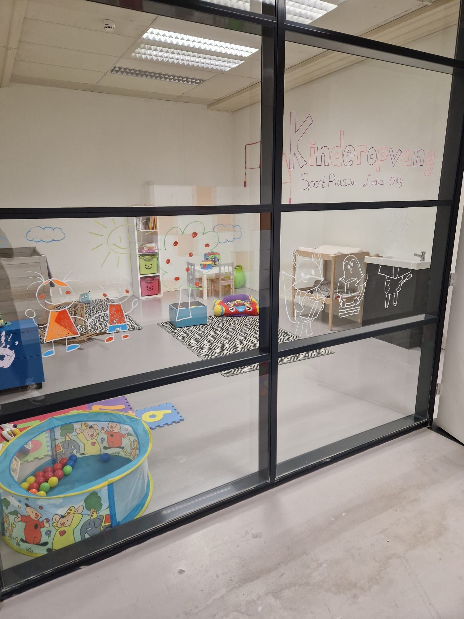 Een kamer met veel speelgoed erin en een raam.