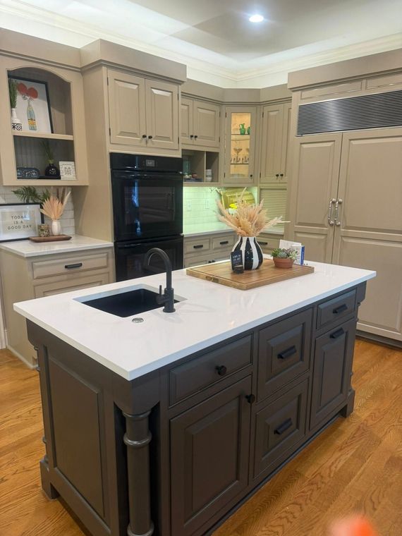 Modern kitchen with dark island, white countertop, and beige cabinets