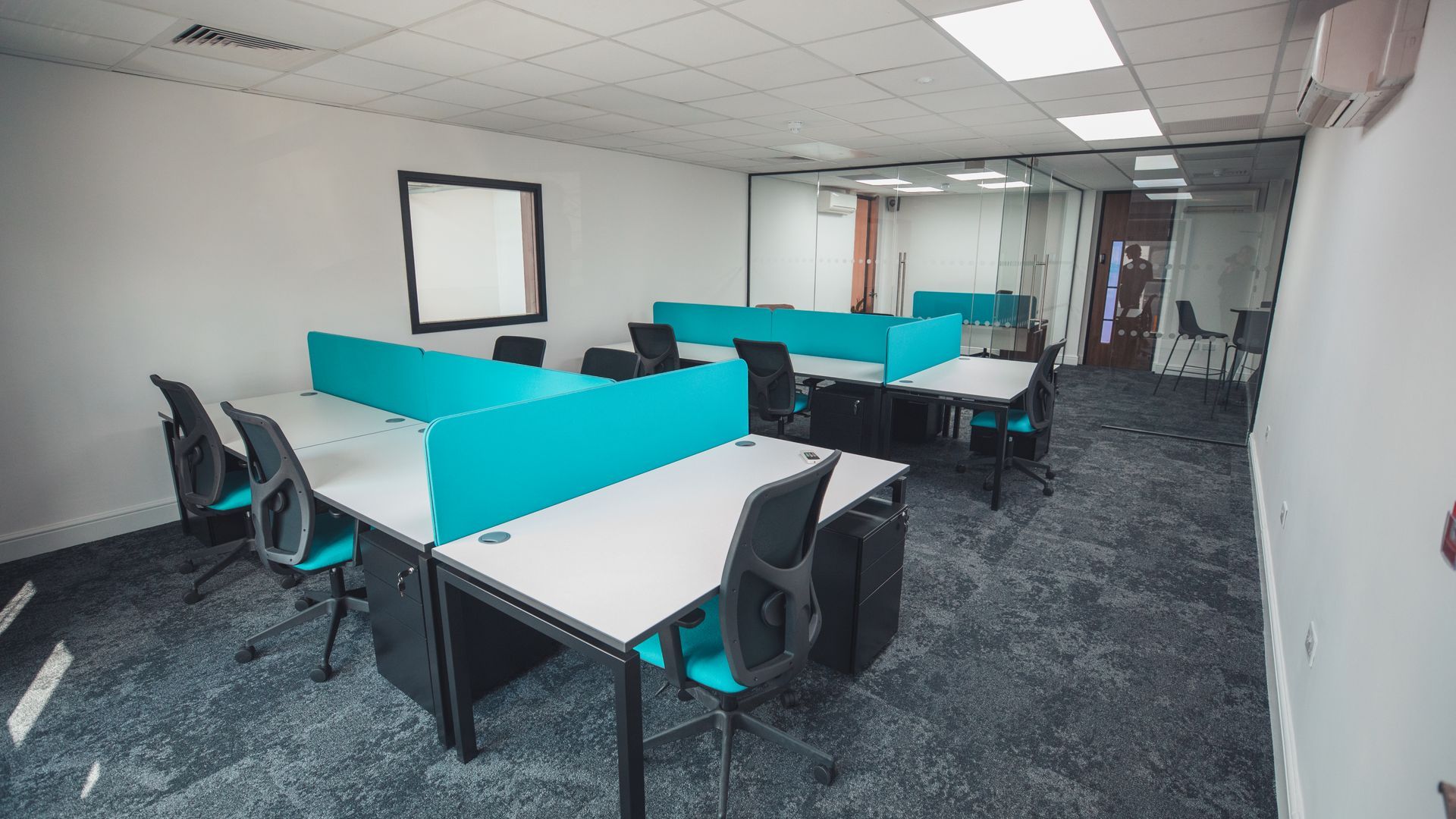 A large office with a lot of desks and chairs.