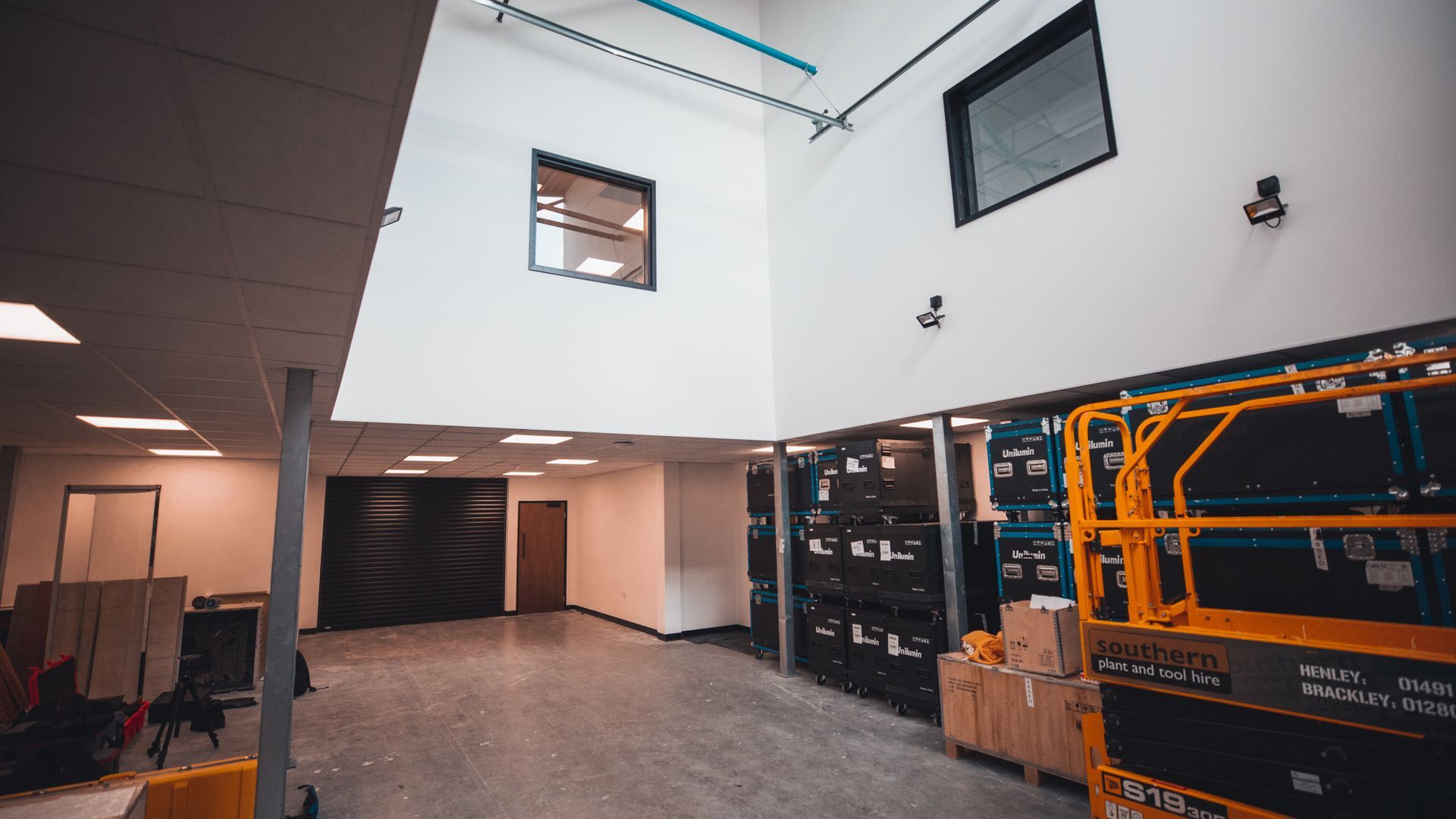 A large warehouse with a lot of boxes and a lift.