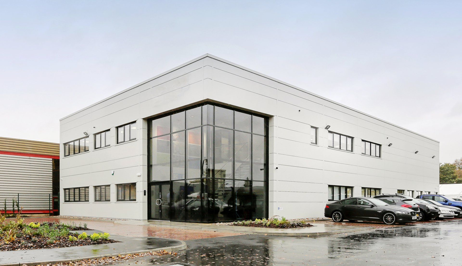 A white building with a lot of windows and cars parked in front of it