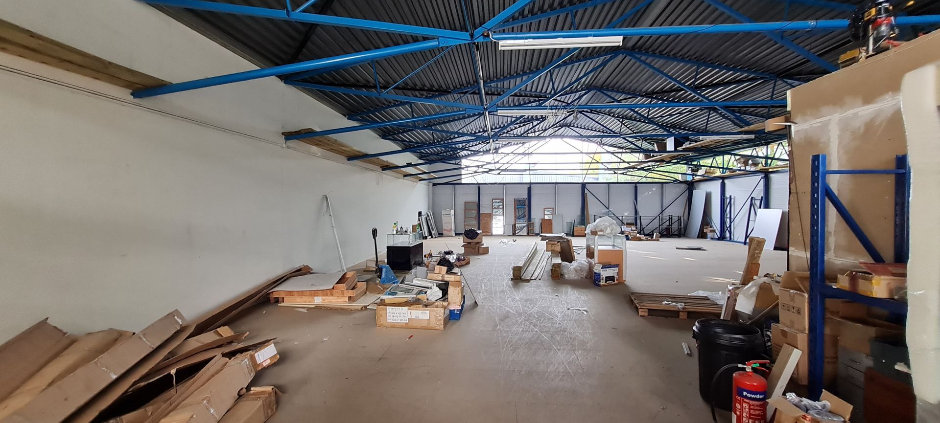 A large warehouse filled with lots of boxes and a fire extinguisher.