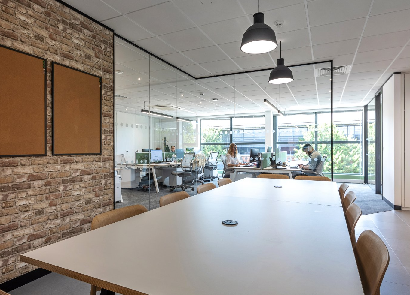 Conference desk & individual desks near large window by Glenside