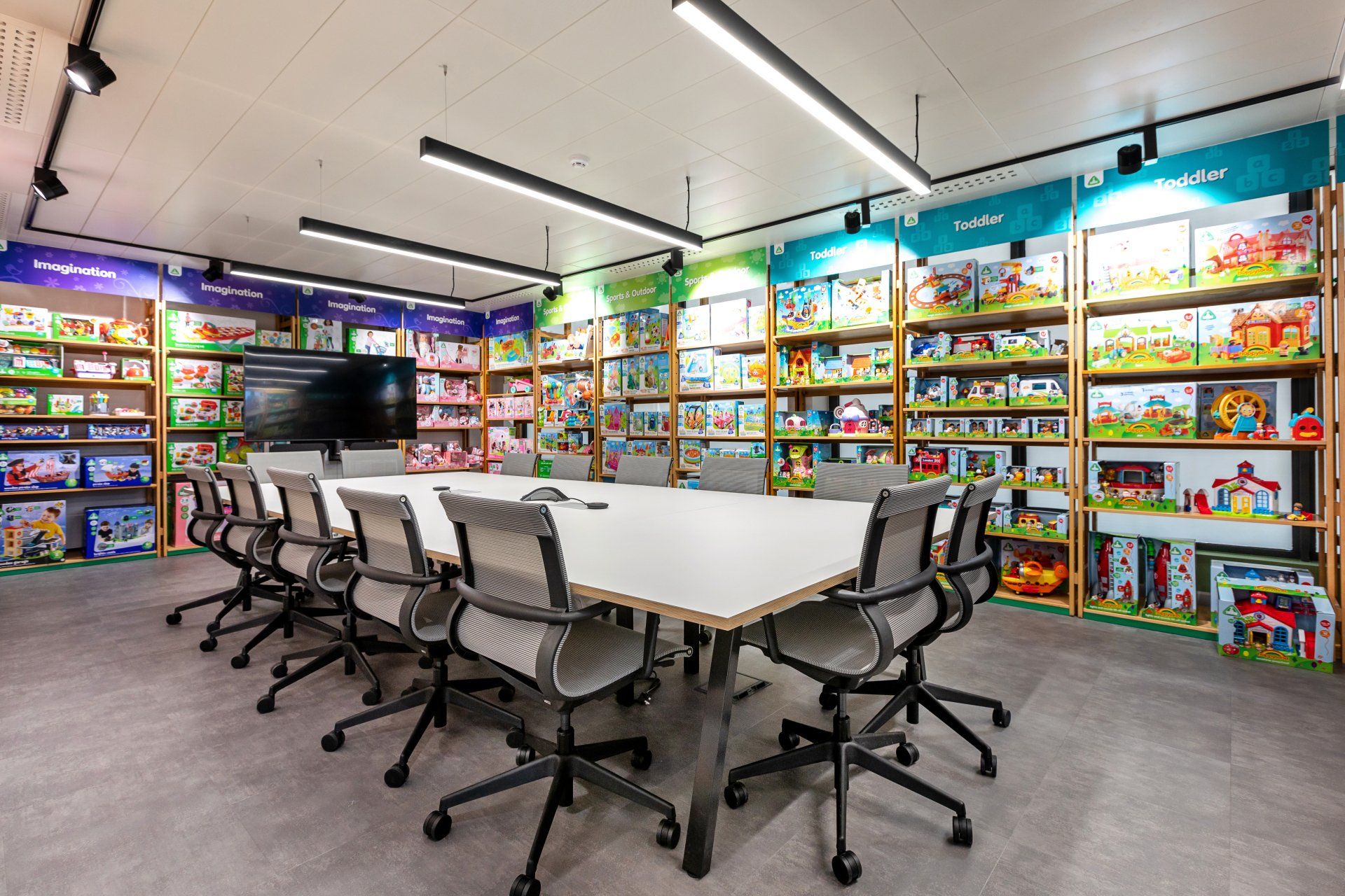 A conference room with a long table and chairs in a toy store.