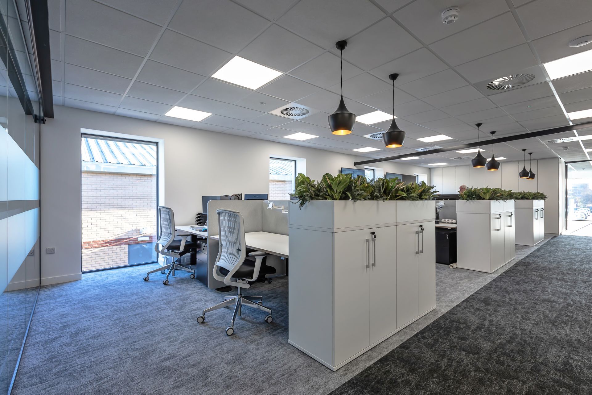 A large office with a lot of desks and chairs.
