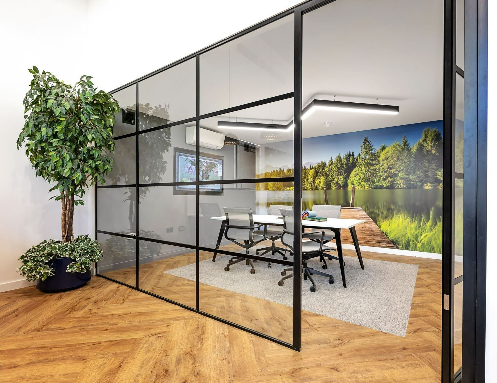 A room with a table and chairs and a glass wall.