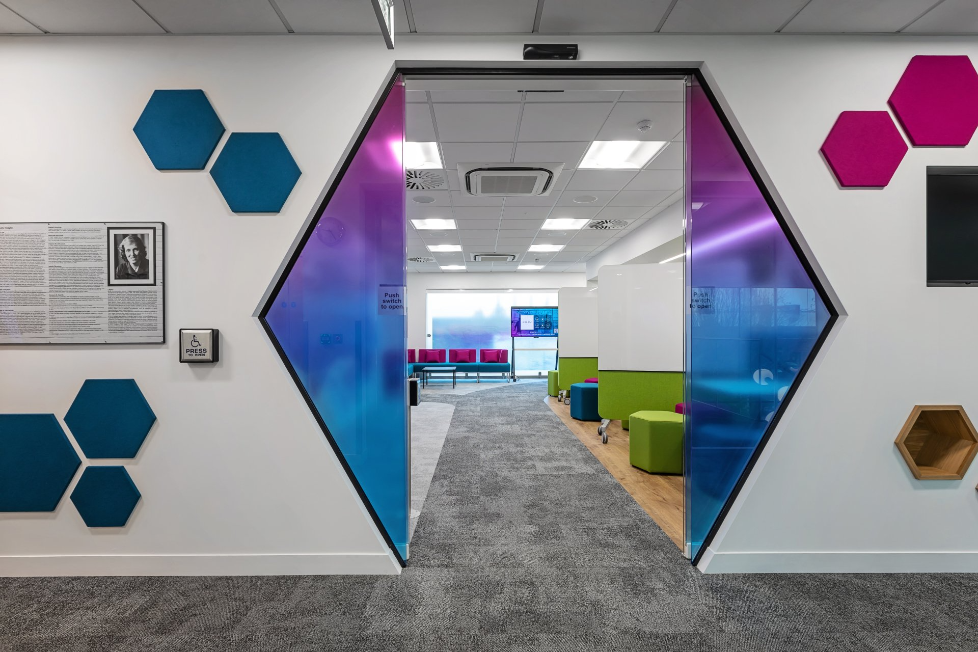 A hallway in a building with blue and pink hexagons on the walls.