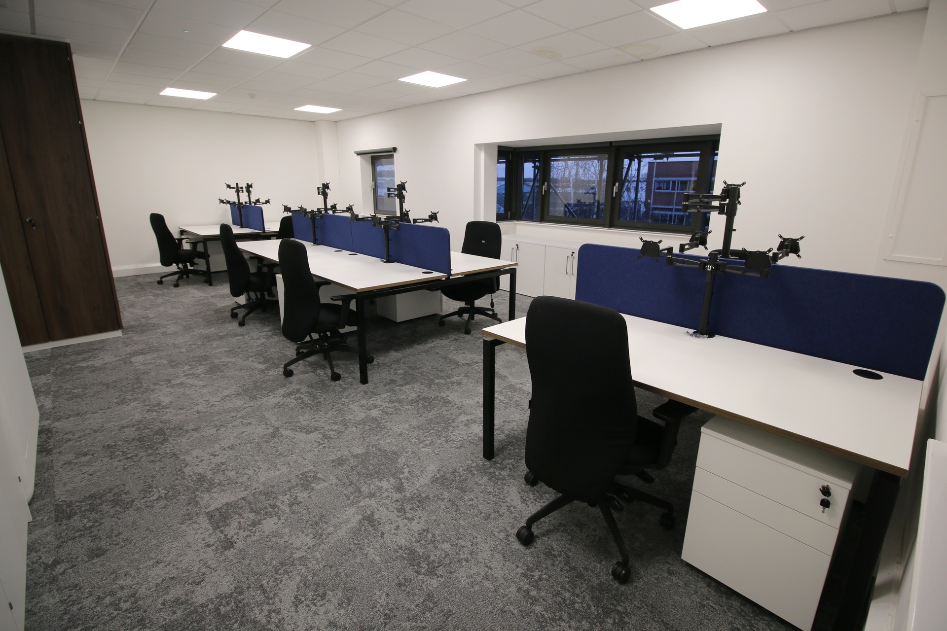A room with a lot of desks and chairs in it.