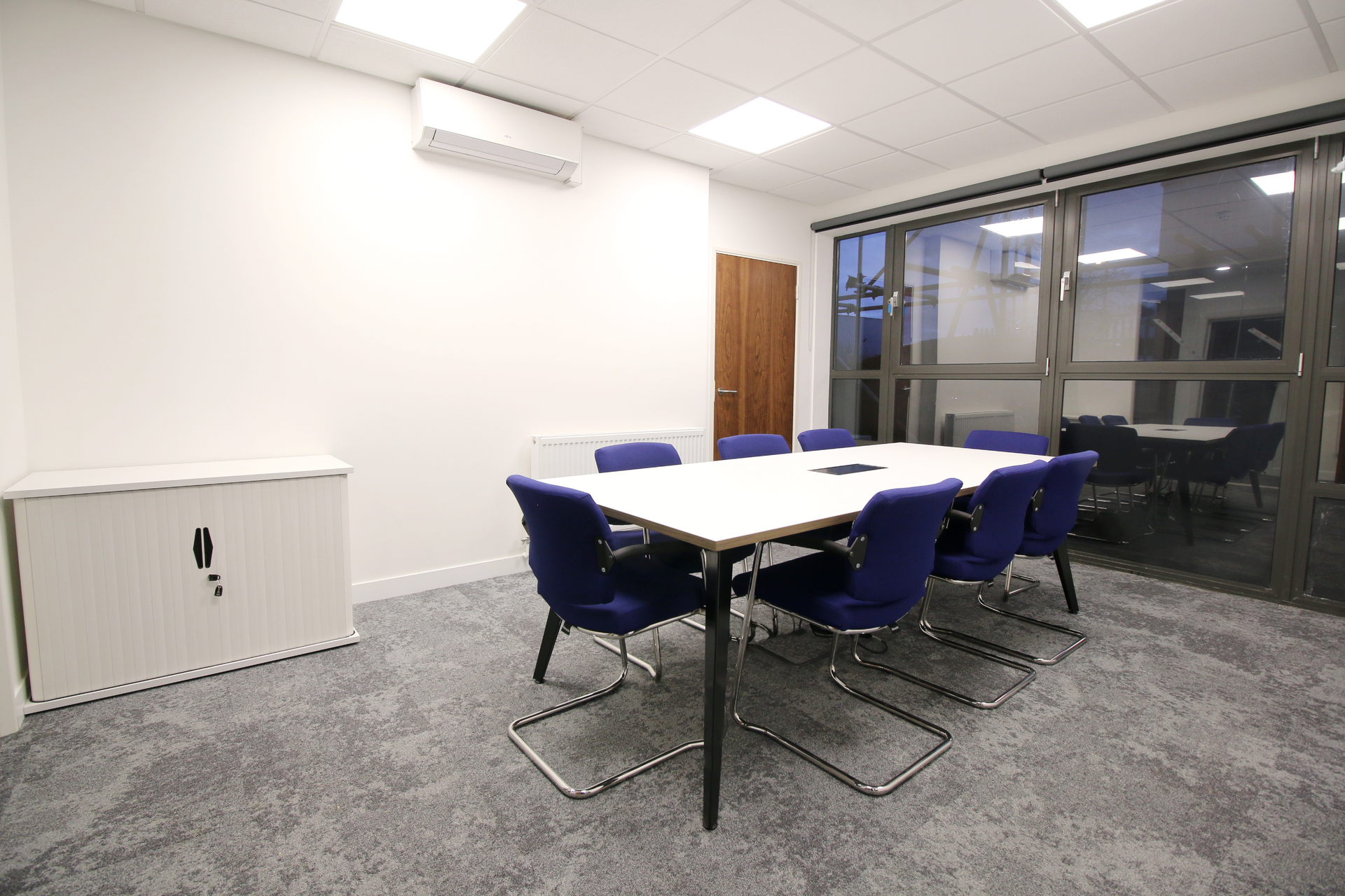 A conference room with a table and chairs in it.