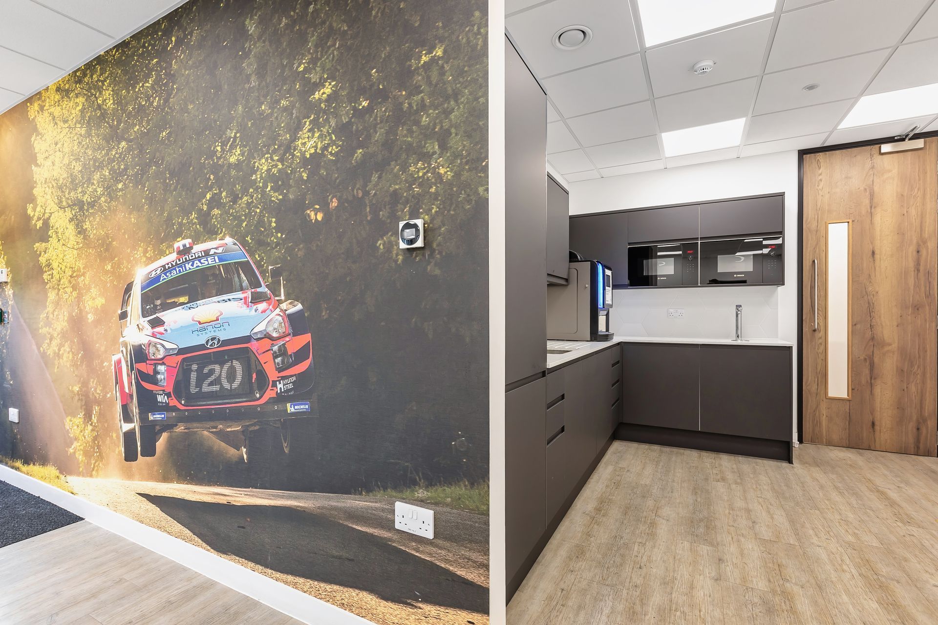 a kitchen with a picture of a car on the wall .