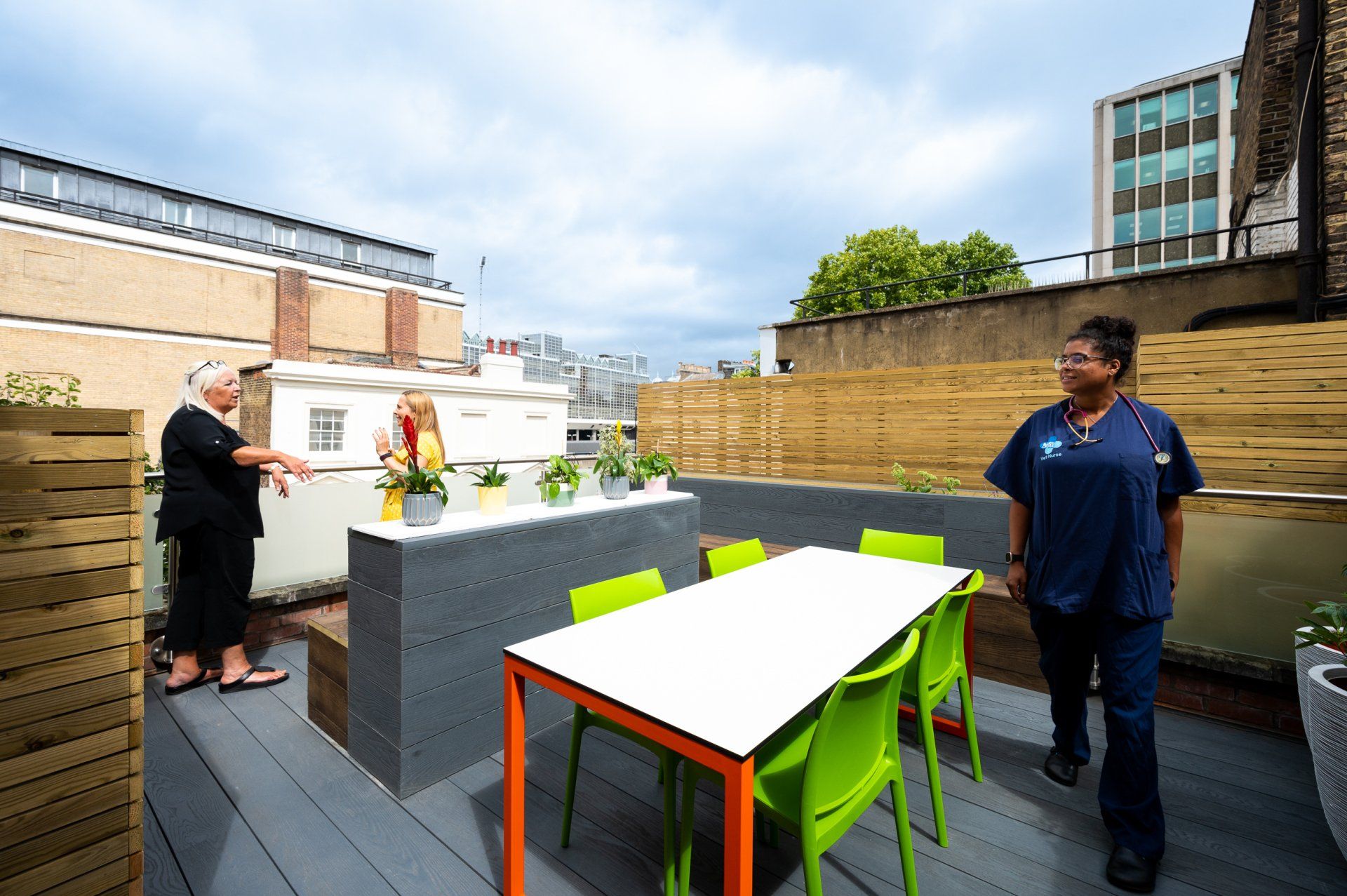a man and a woman are standing on a patio with a table and chairs