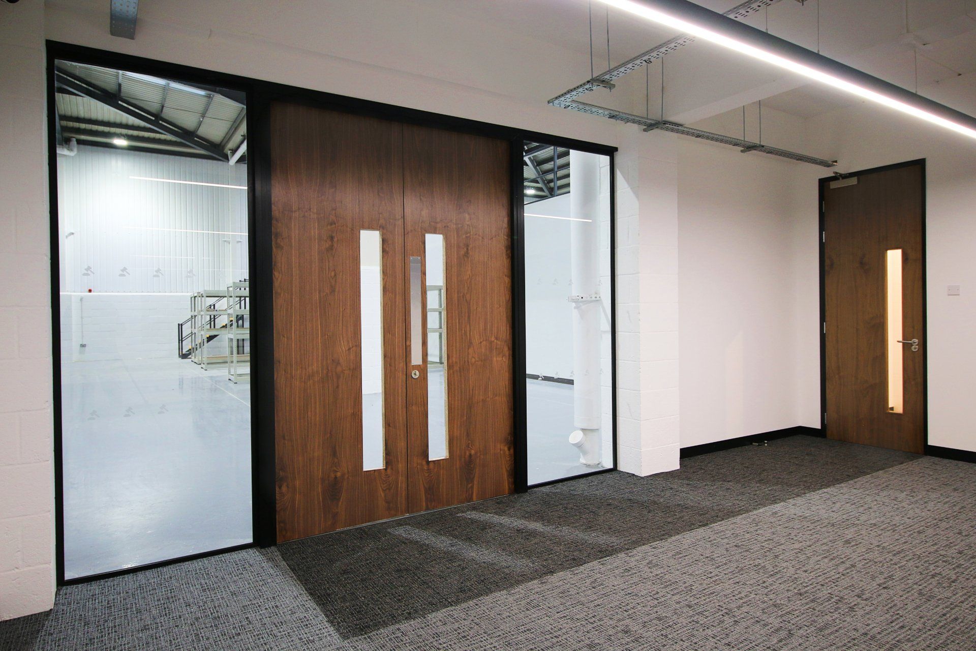a hallway with two wooden doors and two glass doors .