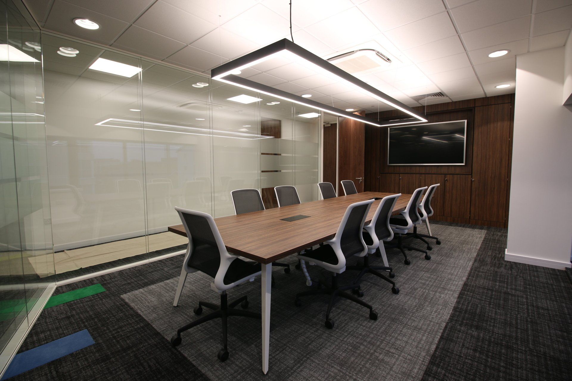A conference room with a long table and chairs.