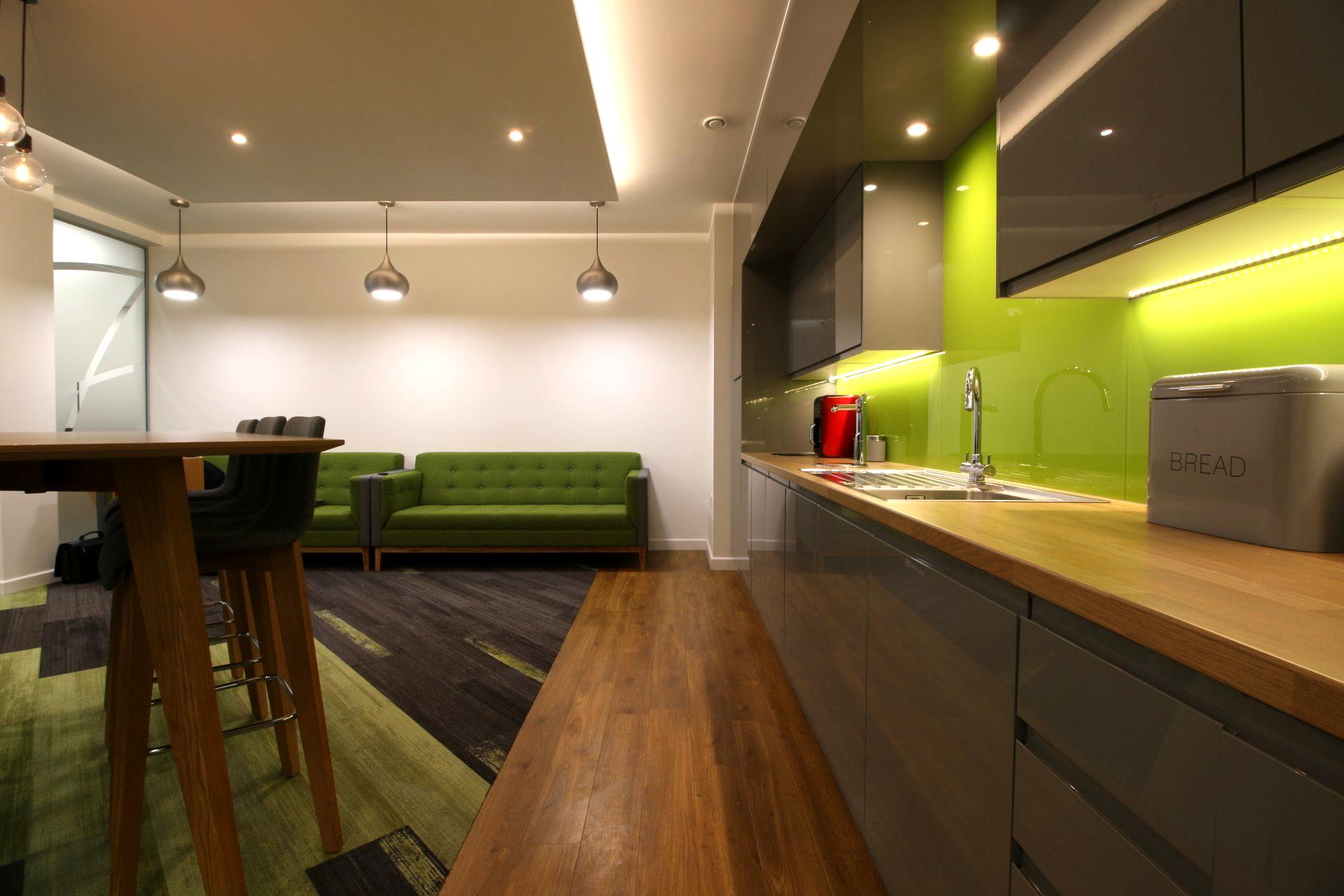 A kitchen with a green couch and a table