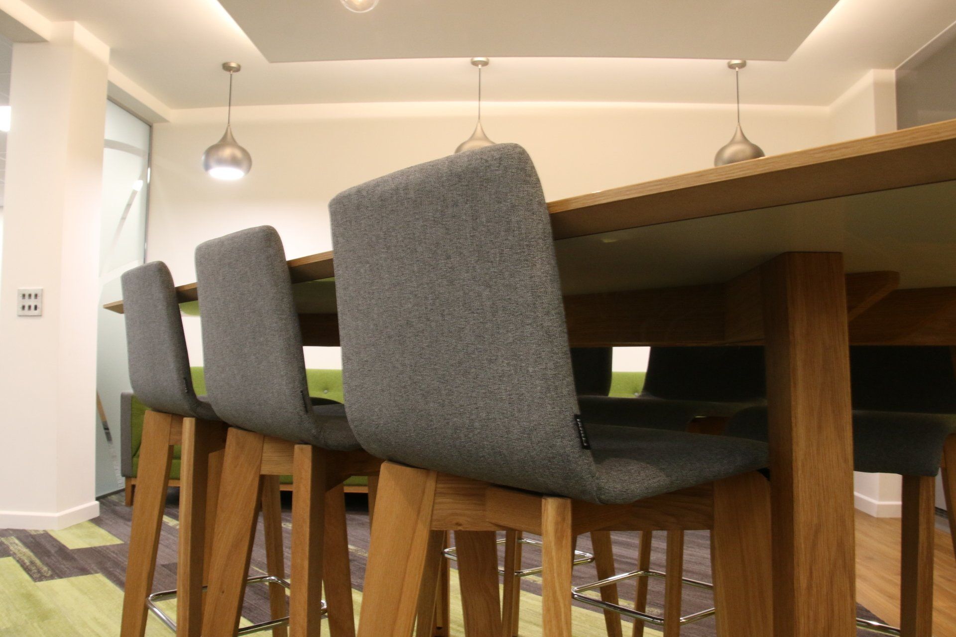 A row of chairs are sitting at a table in a room.