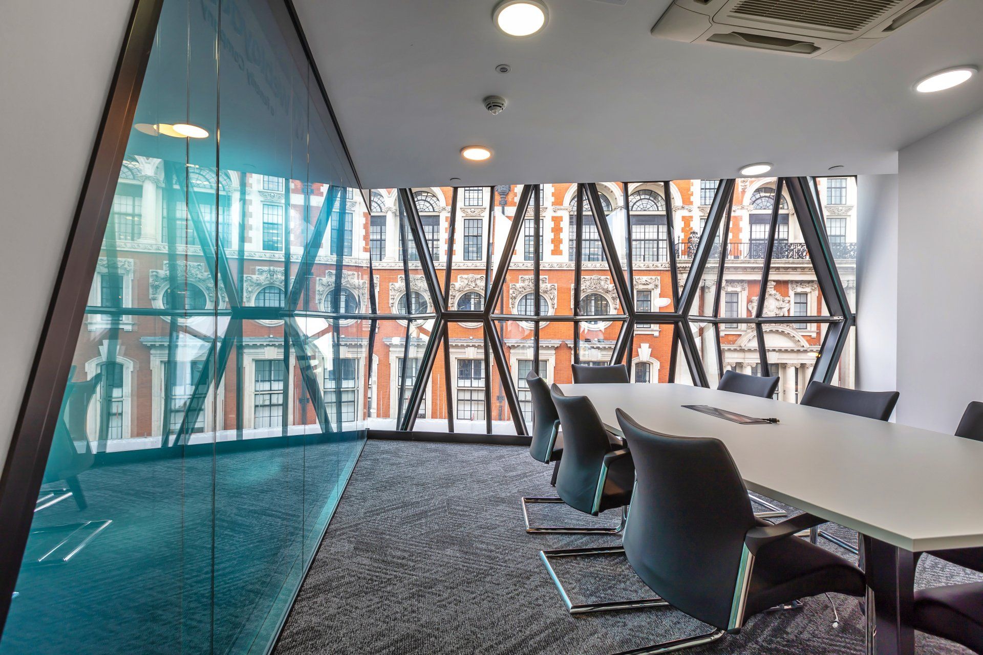 A conference room with a table and chairs and a large window