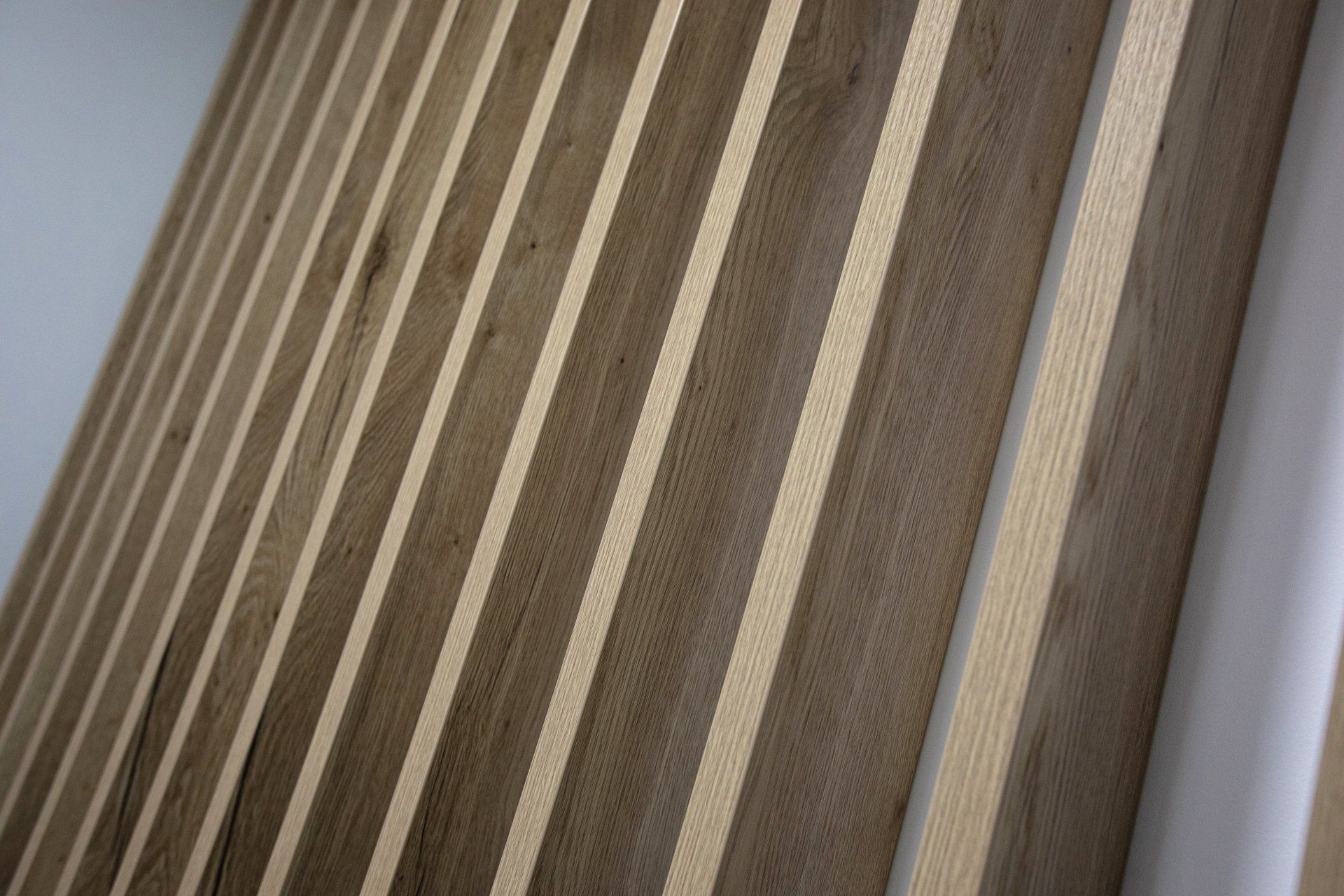 A close up of a wooden wall with wooden stripes on it.