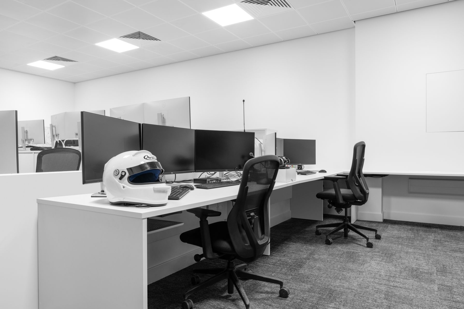 a black and white photo of an office with a helmet on a desk .