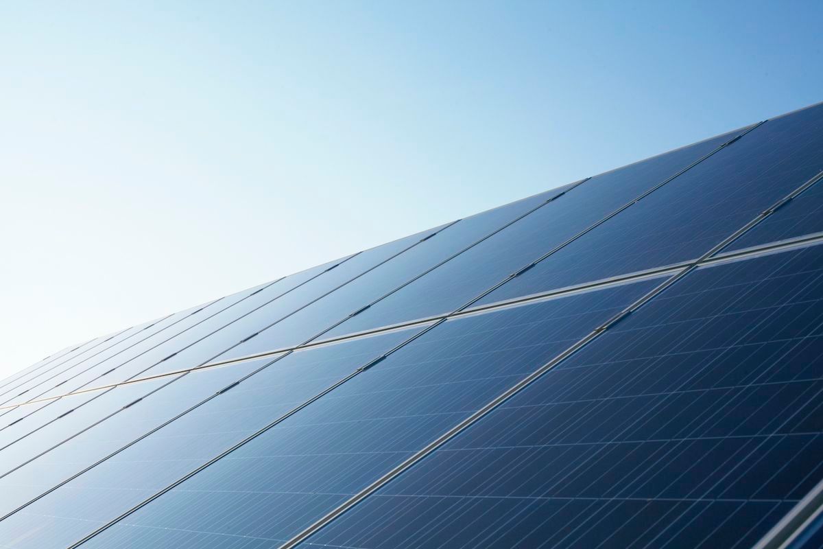 A close up of a row of solar panels against a blue sky.