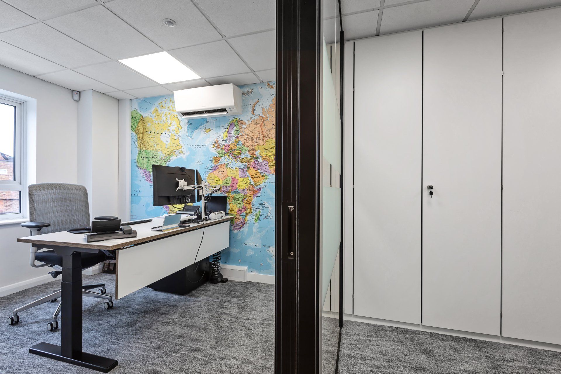 There is a map of the world on the wall in the office.