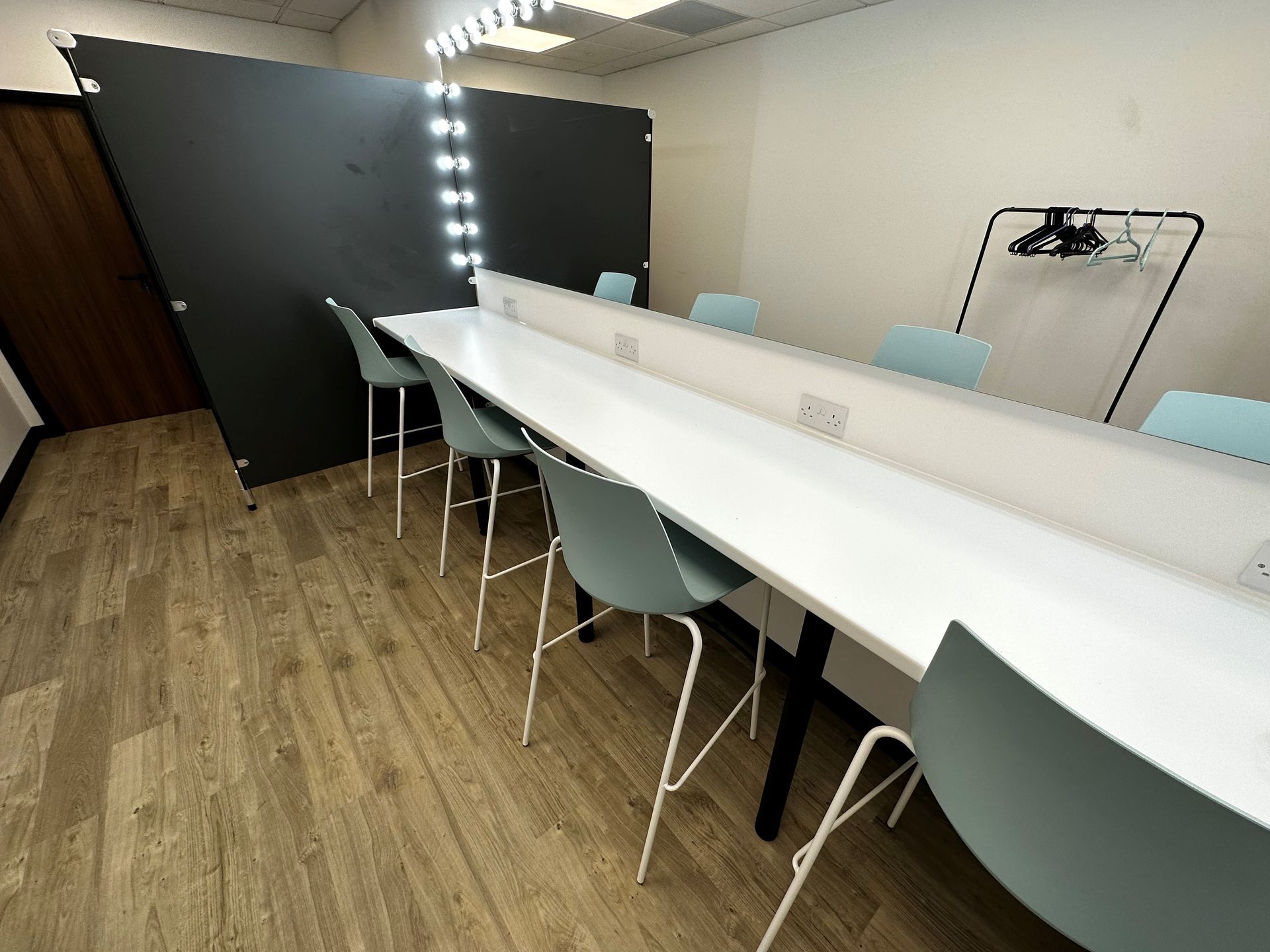 A dressing room with a long table and chairs
