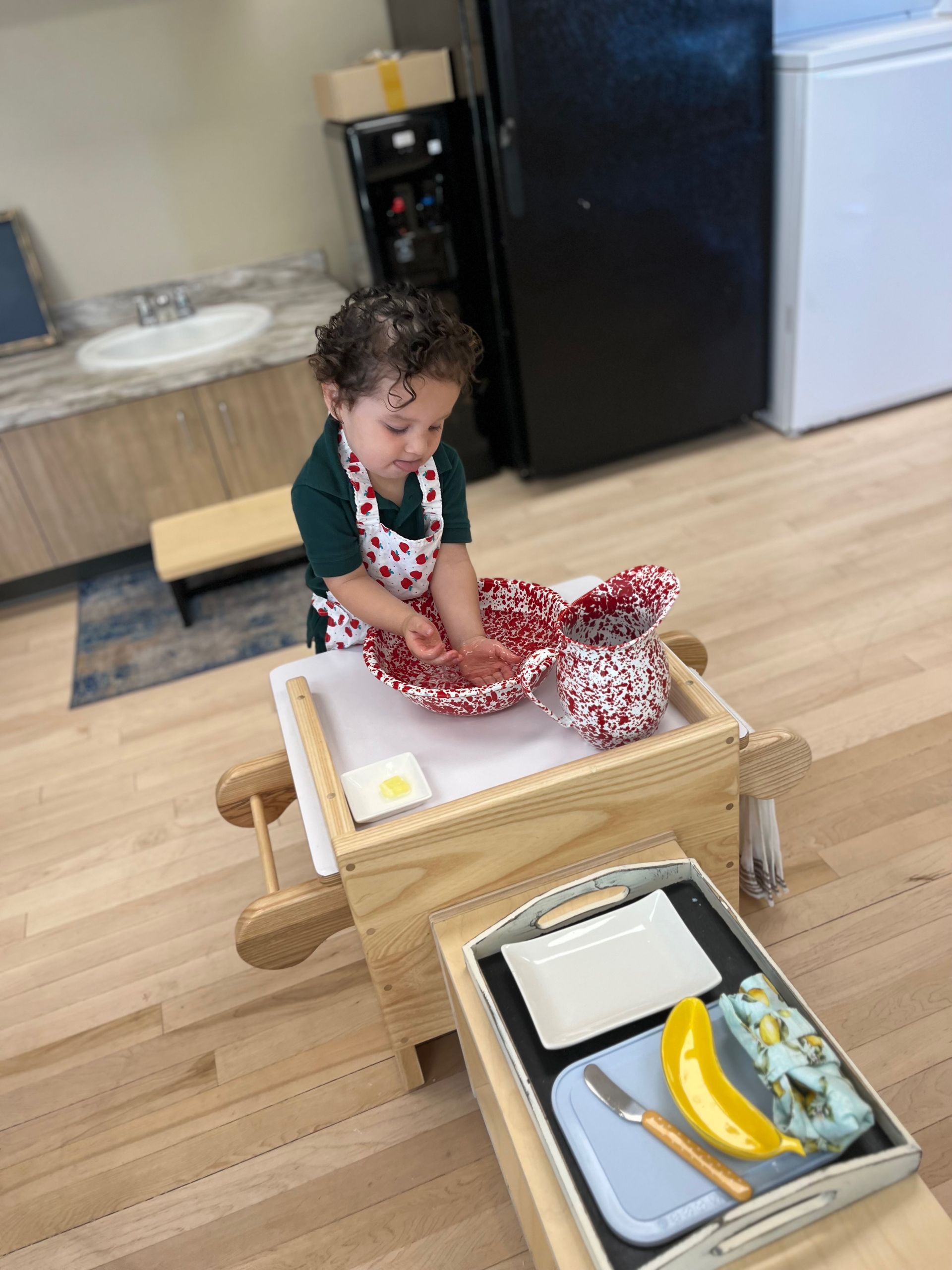 A little girli playing with kitchen utensils.