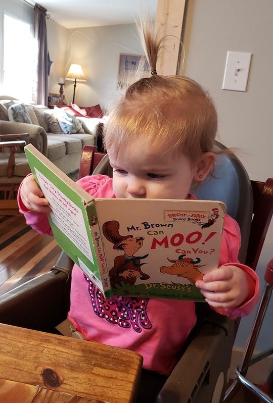 Support for children ages birth–5 with developmental delays or neurological conditions. Early intervention services in York County, SC. Early Intervention York, SC. A child sits in a high chair, wearing a pink shirt, while holding and looking at a book titled