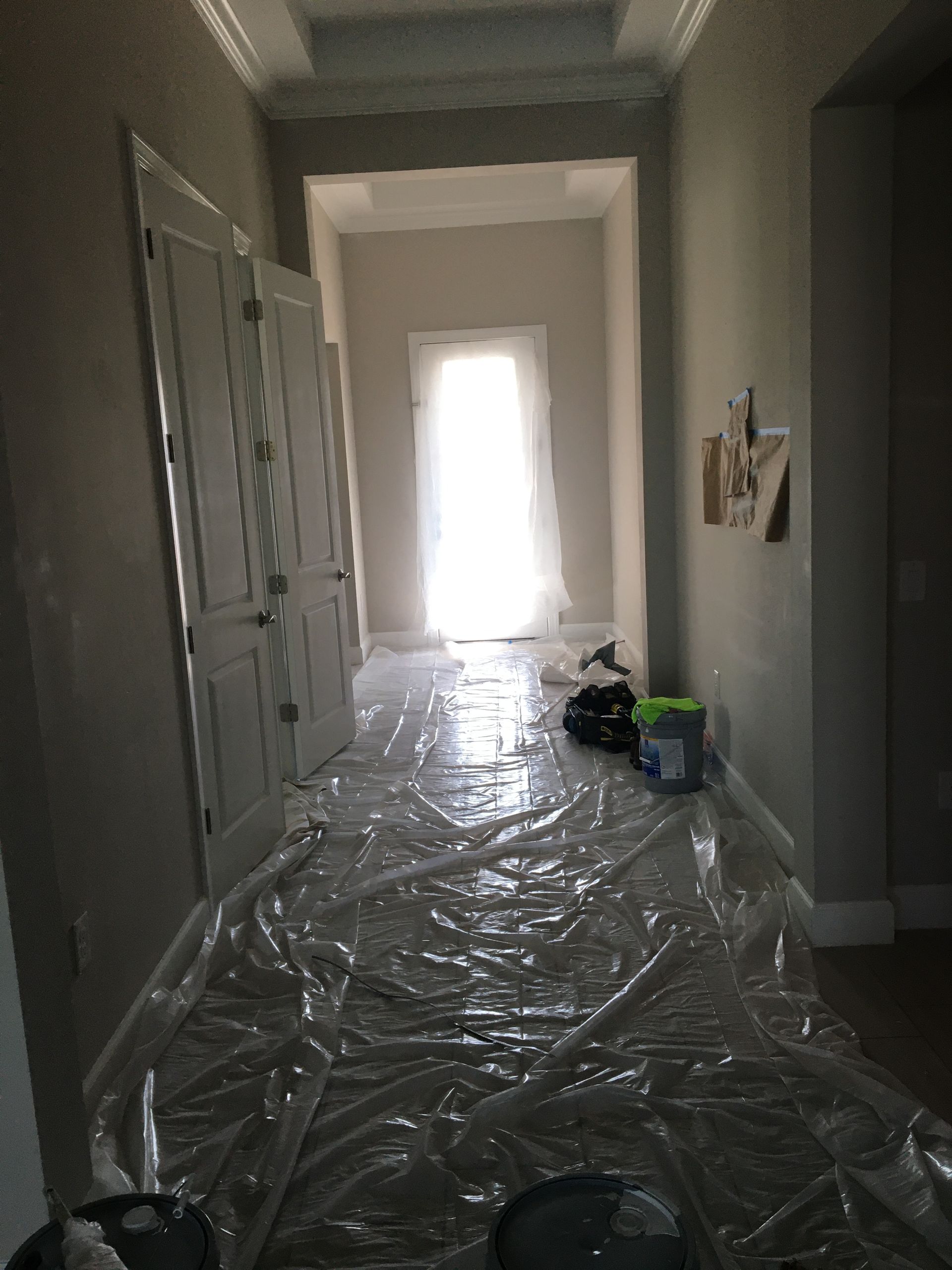 Hallway covered in protective plastic, prepared for residential painting services and interior renovations.