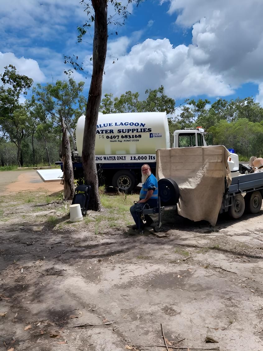 A Man Is Sitting On A Bench In Front Of A Truck — Blue Lagoon Water Supplies In Urangan, QLD
