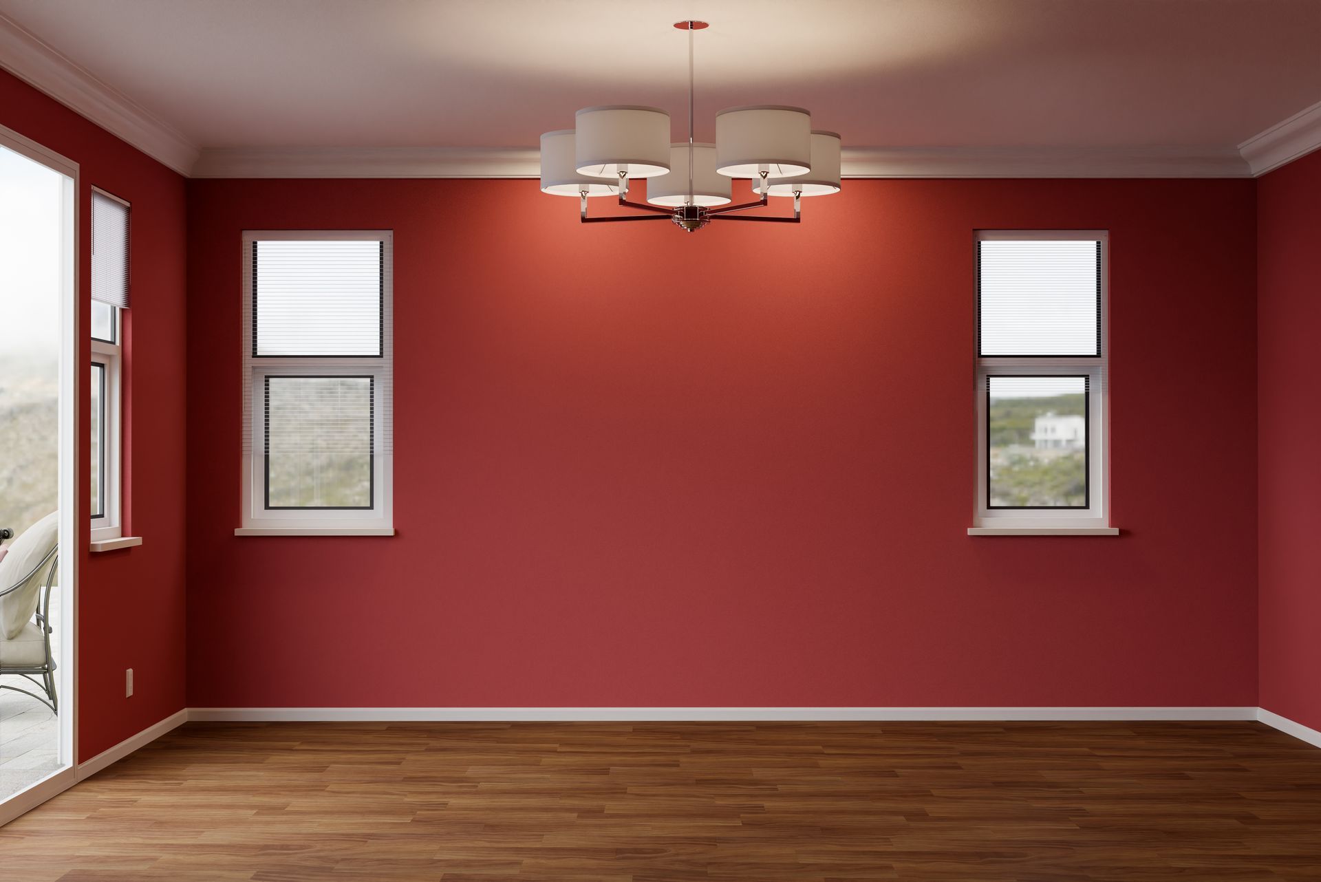 Empty room with red walls, white trim, and a chandelier. Two windows and a wood floor.