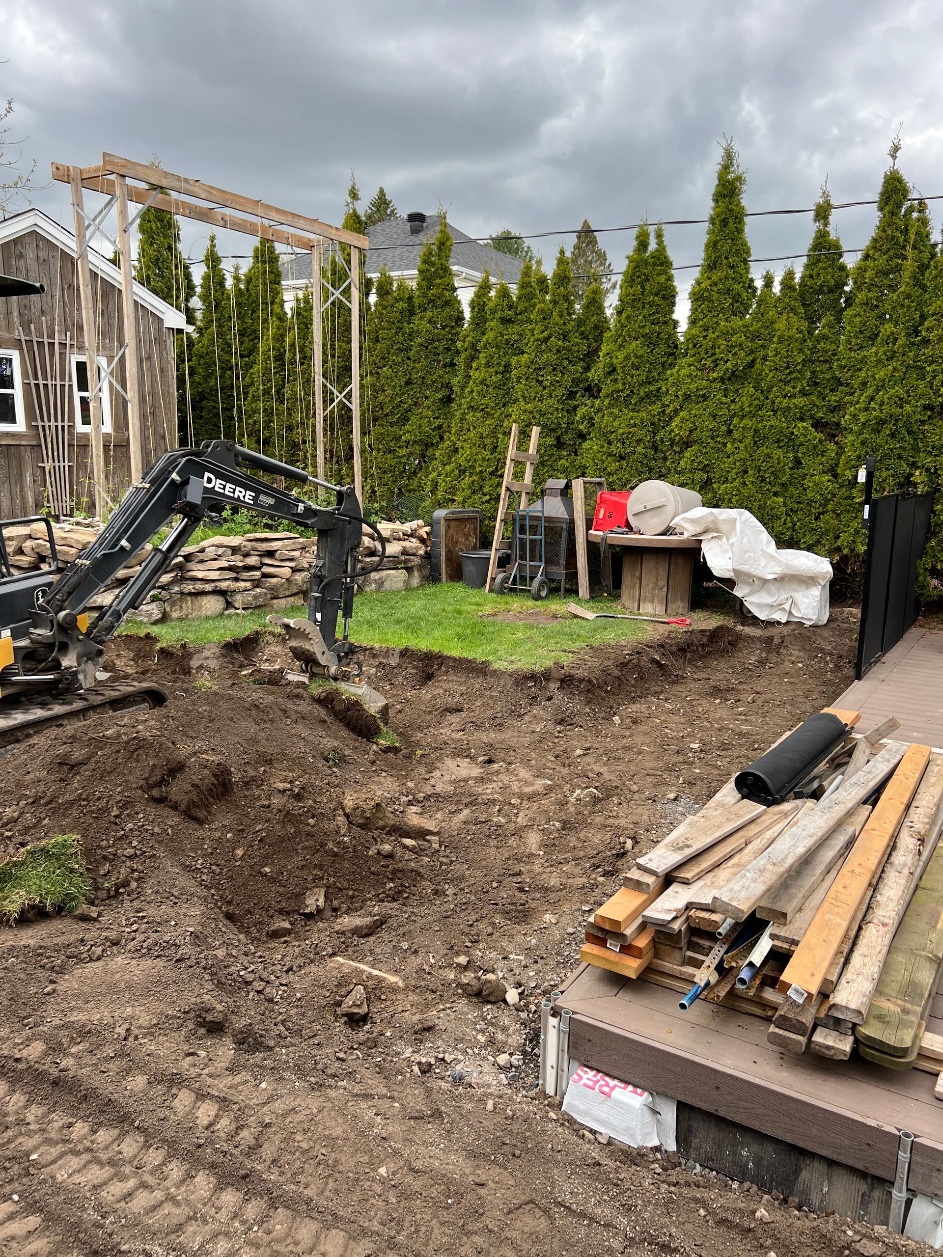 Un chantier avec un tas de bois et un bulldozer.