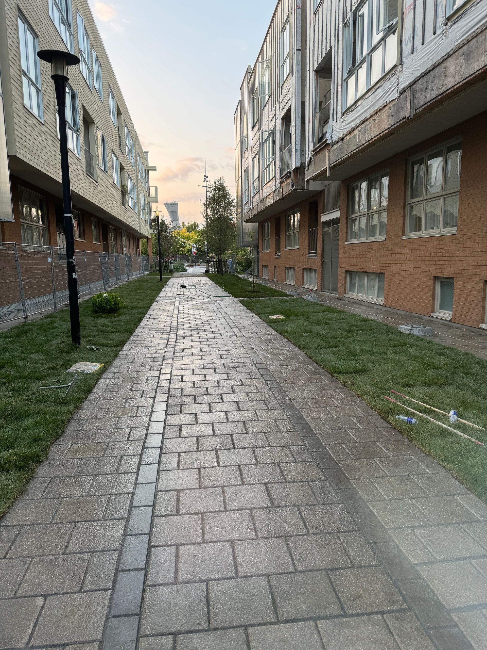 Une passerelle en briques entre deux bâtiments dans un quartier résidentiel.