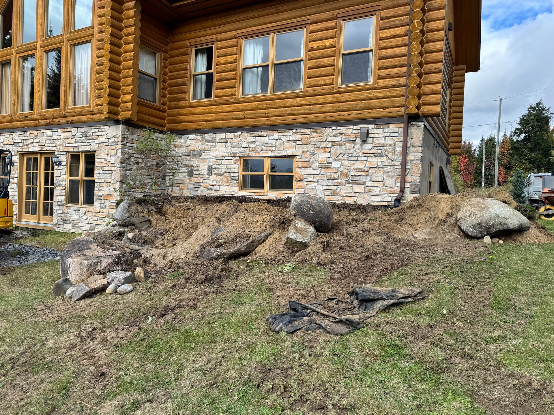 Une grande cabane en rondins avec beaucoup de fenêtres est en cours de construction.
