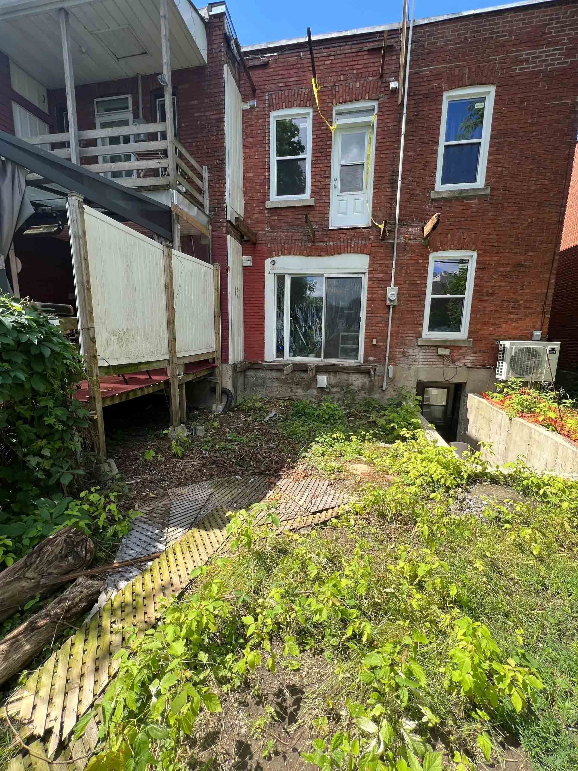 Un escalier menant à une cour arrière avec un tracteur et un foyer.