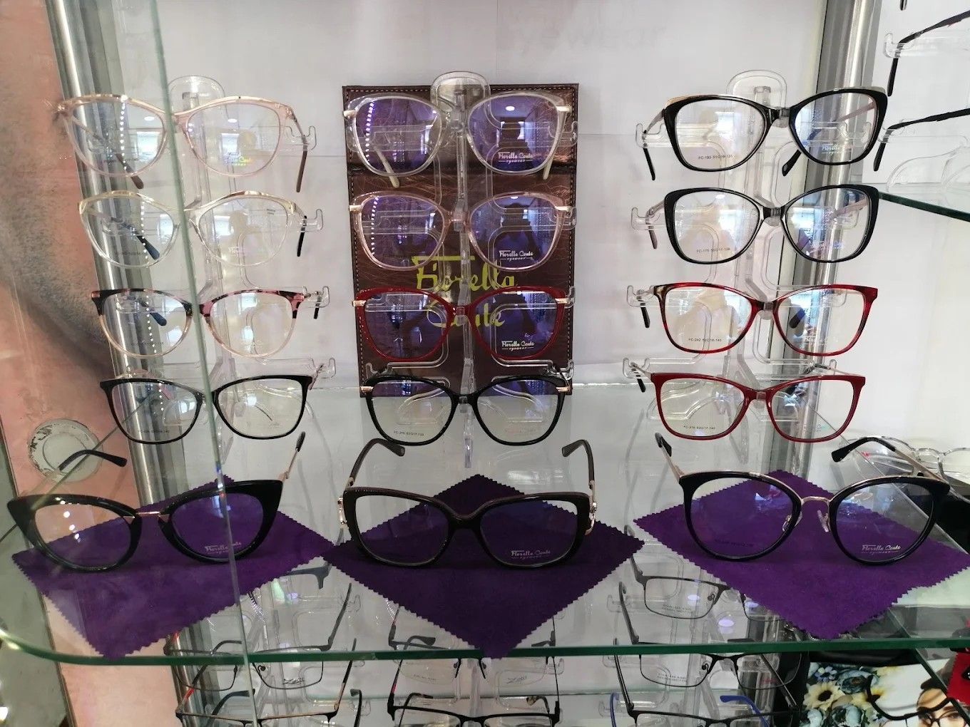 Gafas expuestas en estantes de cristal en una luminosa tienda.