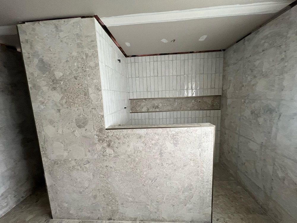 A Corner of a Room With a Concrete Wall and White Tiles — S & S Tiling and Rendering in Cobar, NSW