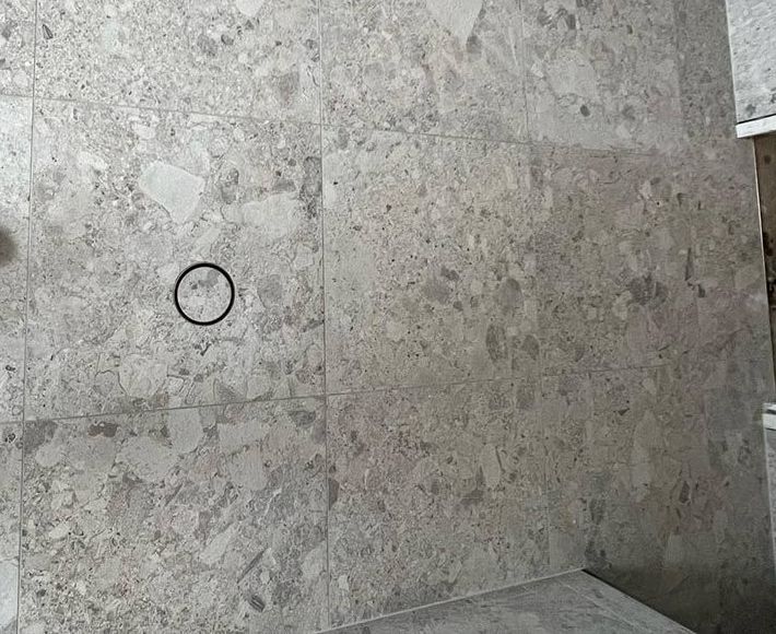 A Person is Standing on a Tiled Floor With a Circle in the Middle — S & S Tiling and Rendering in Dubbo, NSW
