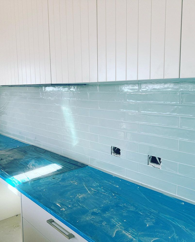 A Kitchen With White Cabinets and a Blue Counter Top — S & S Tiling and Rendering in Dubbo, NSW