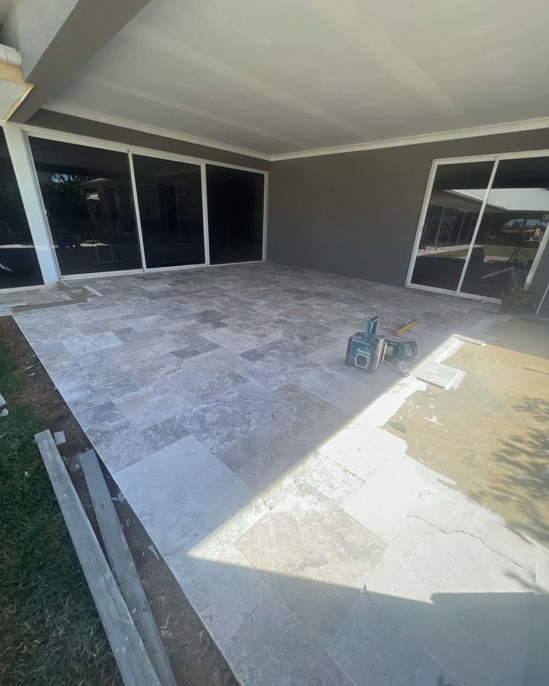 A Patio With Tiles and Sliding Glass Doors is Being Built in a House — S & S Tiling and Rendering in Cobar, NSW