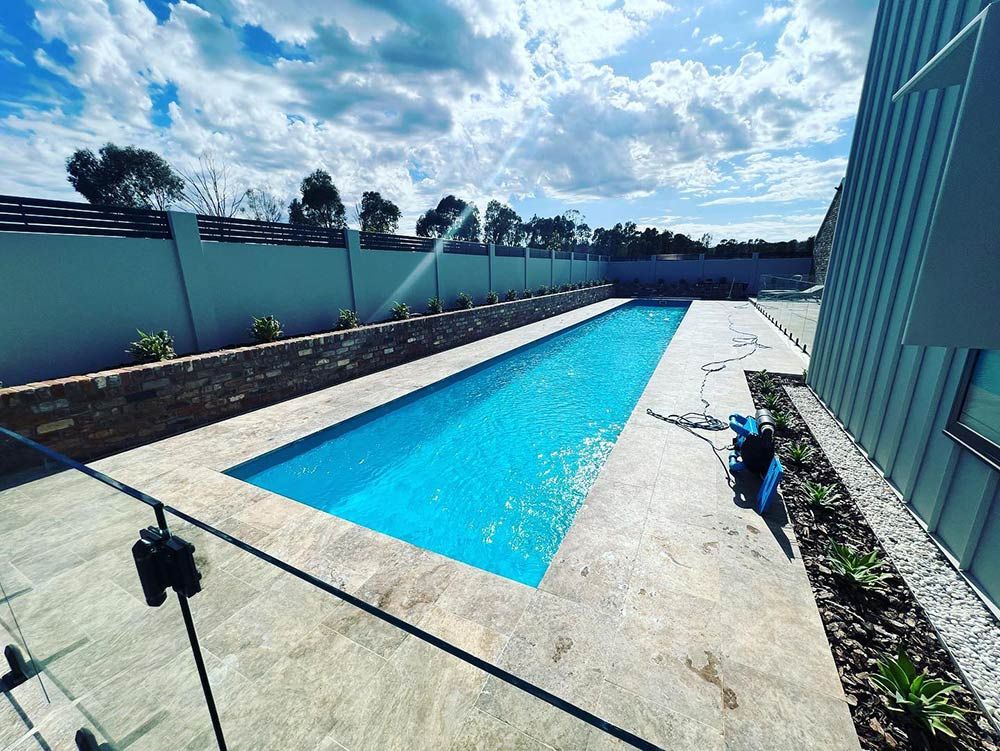 There is a Large Swimming Pool in the Backyard of a House — S & S Tiling and Rendering in Mudgee, NSW