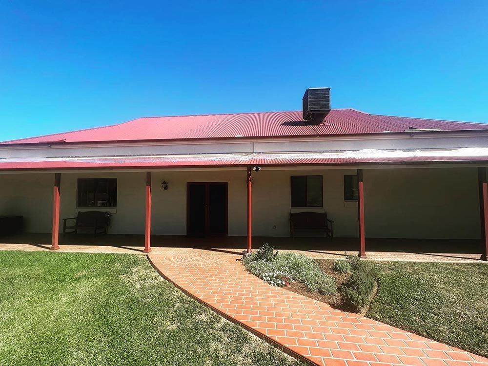 A Large White House With a Red Roof and a Walkway Leading to It — S & S Tiling and Rendering in Mudgee, NSW