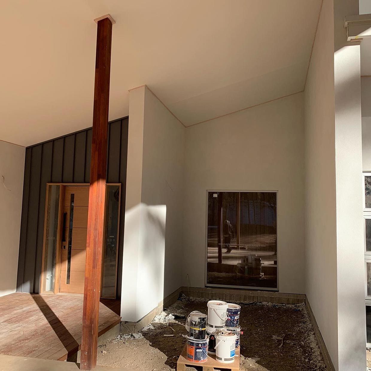 A Building Under Construction With a Wooden Pole in the Middle of It — S & S Tiling and Rendering in Forbes, NSW