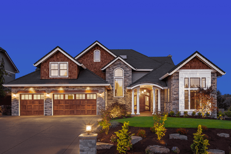 A large house with a lot of windows is lit up at night.