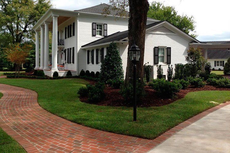 A large white house with a brick walkway leading to it
