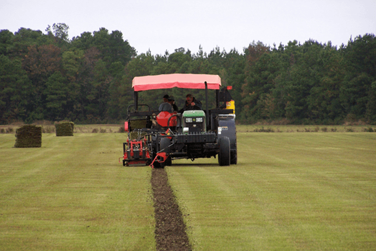 A tractor is cutting grass in a field.