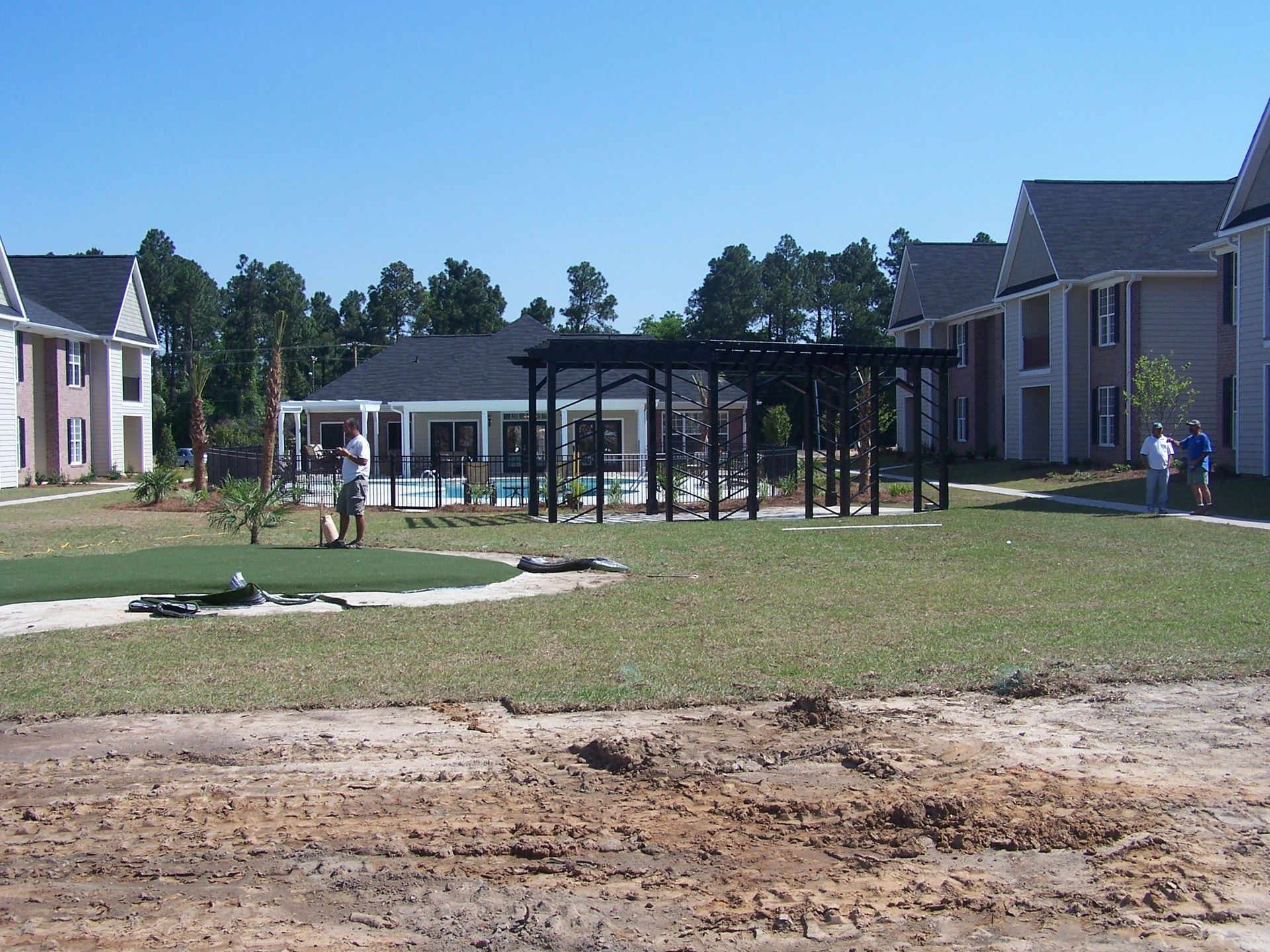 A group of people are standing in front of a row of houses